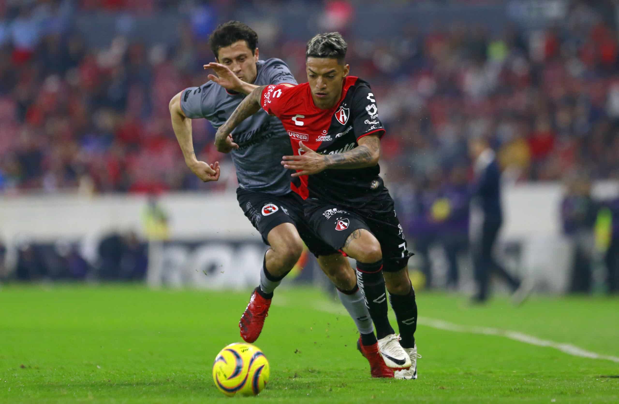 Fernando Madrigal del Tijuana y Raymundo Fulgencio del Atlas disputan el balón durante el juego de la jornada 2.