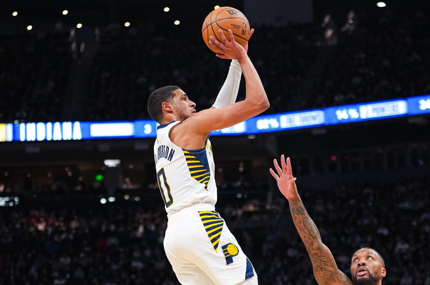 TYRESE HALIBURTON DE LOS PACERS HACE UN TIRO SOBRE DAMIAN LILLARD DE LOS BUCKS