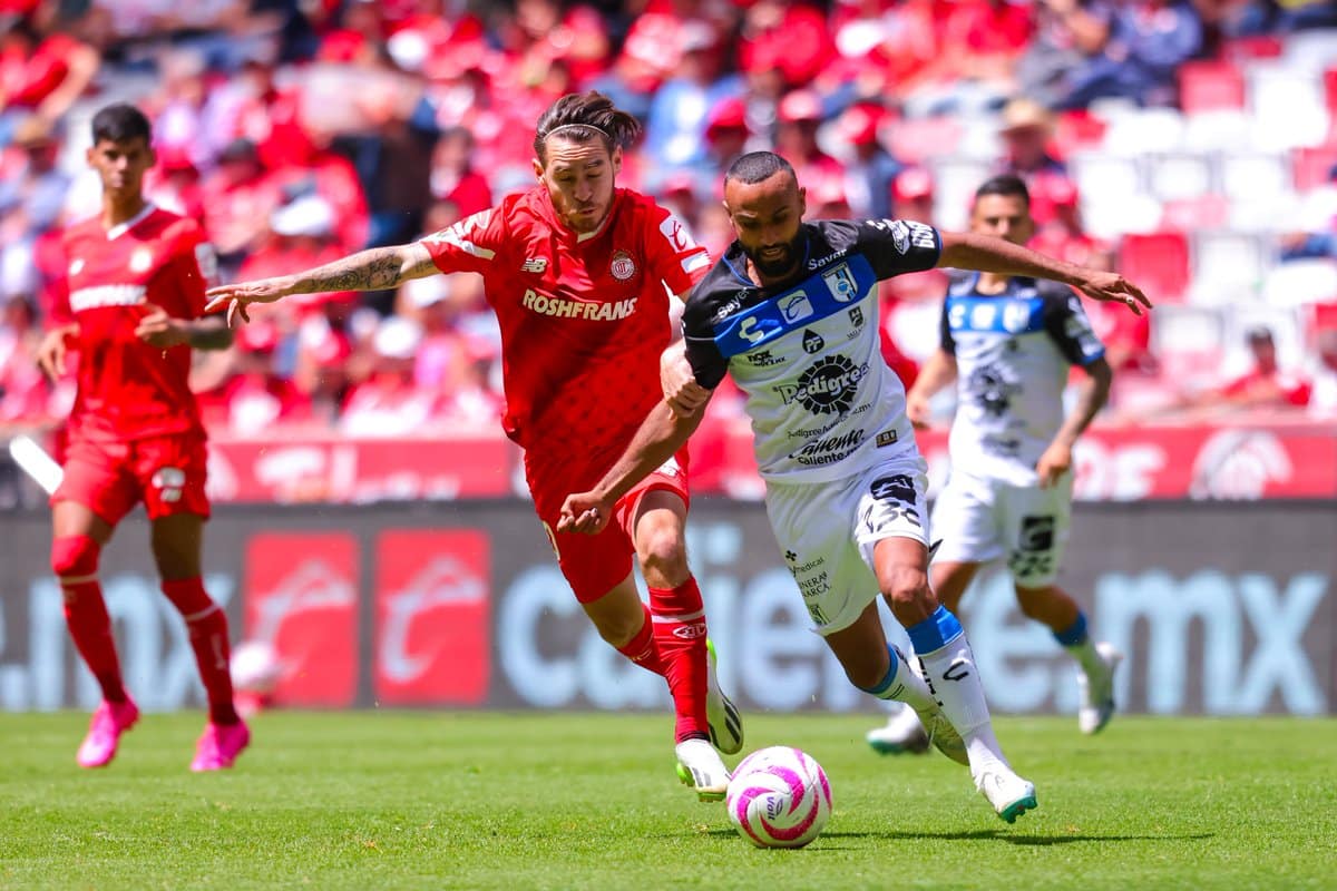 JUGADOR DEL TOLUCA Y DE GALLOS SE DISPUTAN EL BALÓN EN UN PARTIDO