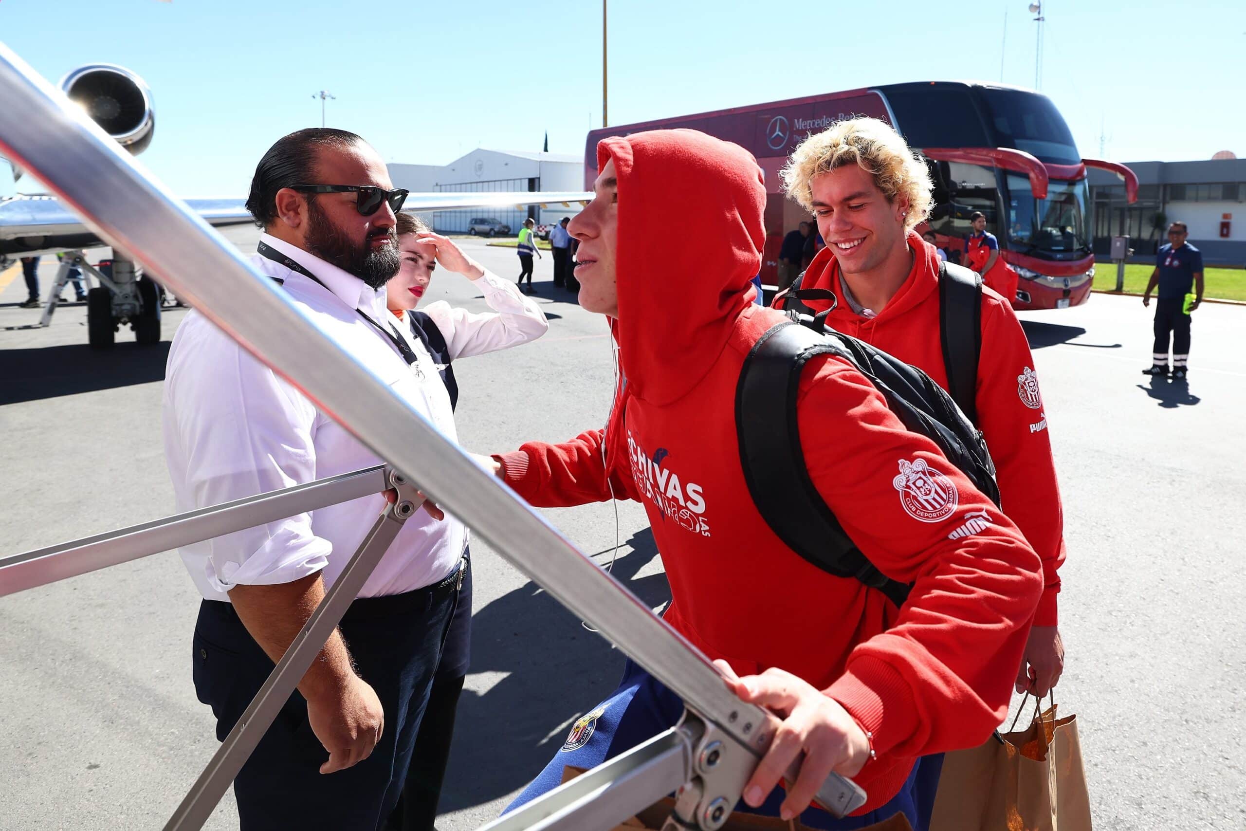 Jugadores de Chivas abordan el avión con rumbo a Canadá.