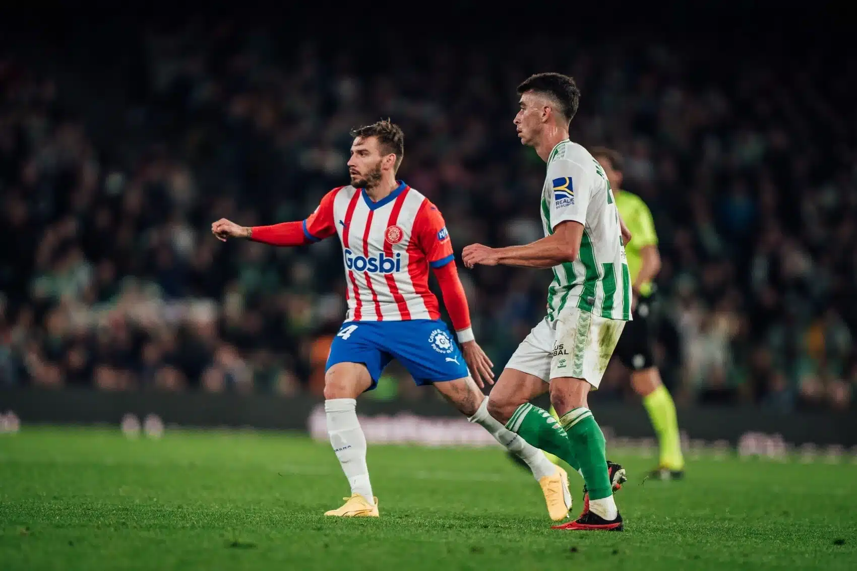 JUGADORES DEL REAL BETIS Y GIRONA SE DISPUTAN LA POSESIÓN DEL BALÓN